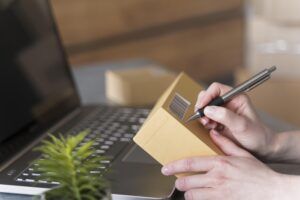side view woman writing box with laptop plant scaled